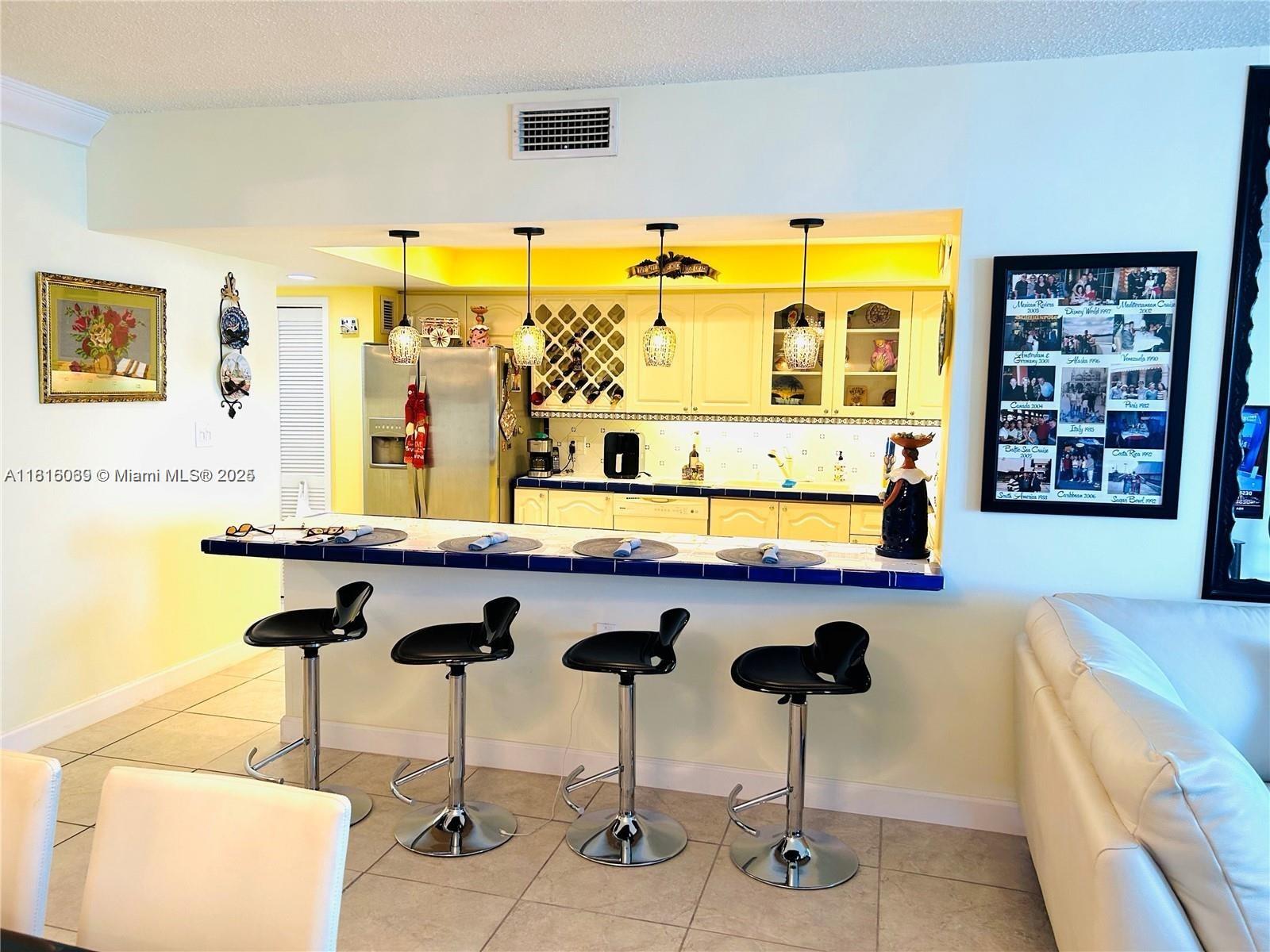 Corinthian Condominiums Miami Beach, FL 33140 - Photo 4 of 19 a kitchen with stainless steel appliances kitchen island a table and chairs in it