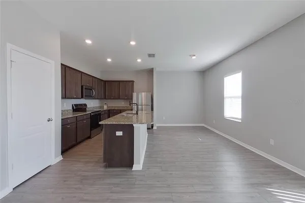 a kitchen with stainless steel appliances granite countertop a stove a sink and a refrigerator