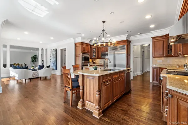 a large kitchen with stainless steel appliances granite countertop a lot of counter space and wooden floor