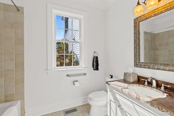 a bathroom with a granite countertop toilet a sink and a mirror