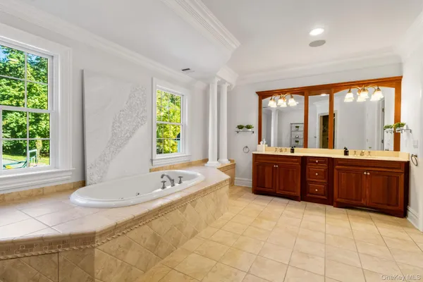 a spacious bathroom with a tub sink and mirror