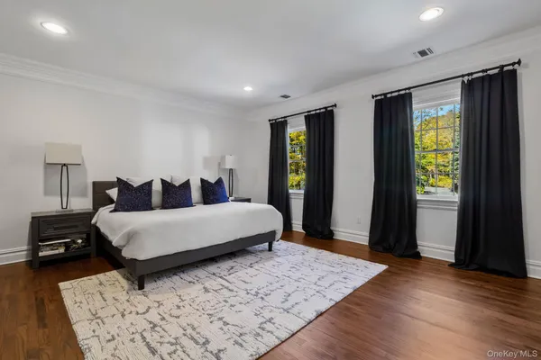 a bed sitting in a spacious bedroom next to a window