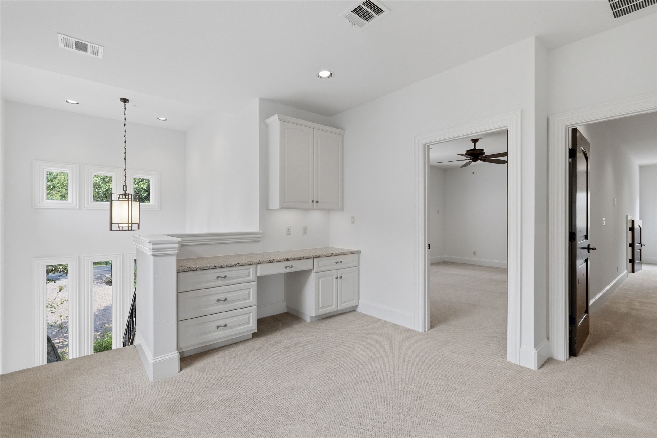 1414 The High Road Austin, TX 78746 - Photo 24 of 40 A loft space offers built-in cabinetry, elegant lighting, and a view of the outside.