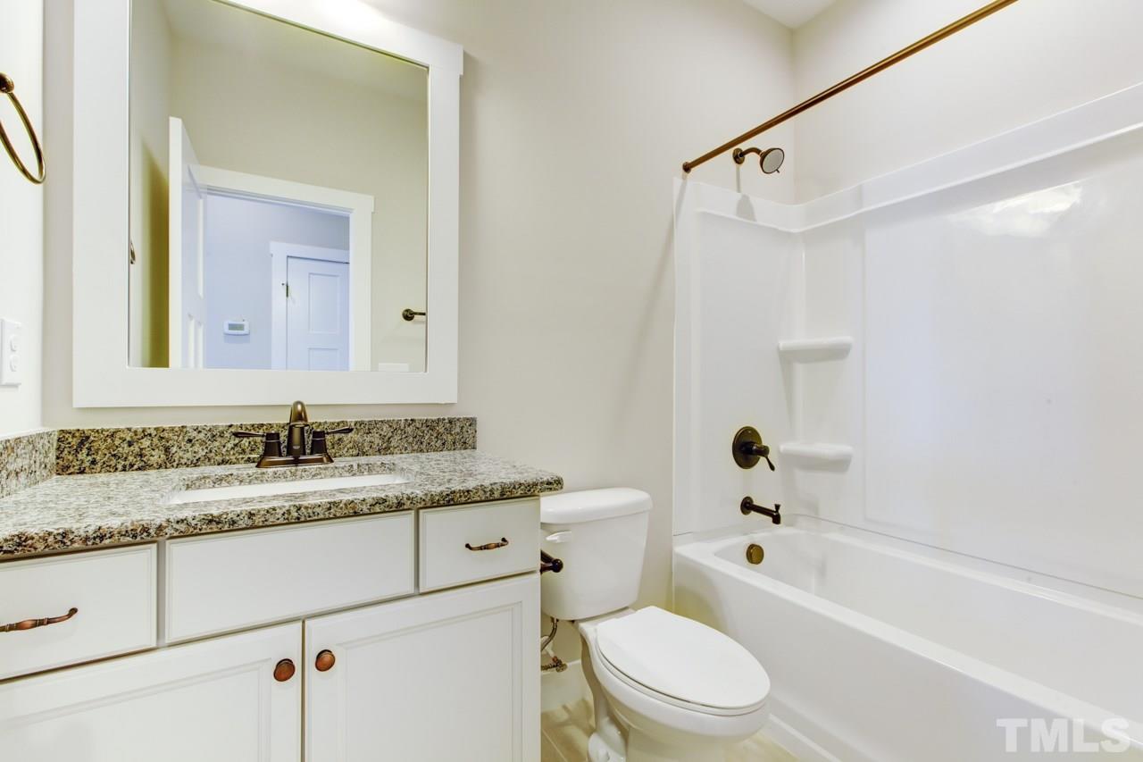1033 Sky Wave Trail, Unit 8 Raleigh, NC 27603 - Photo 15 of 23 a bathroom with a granite countertop sink toilet and shower