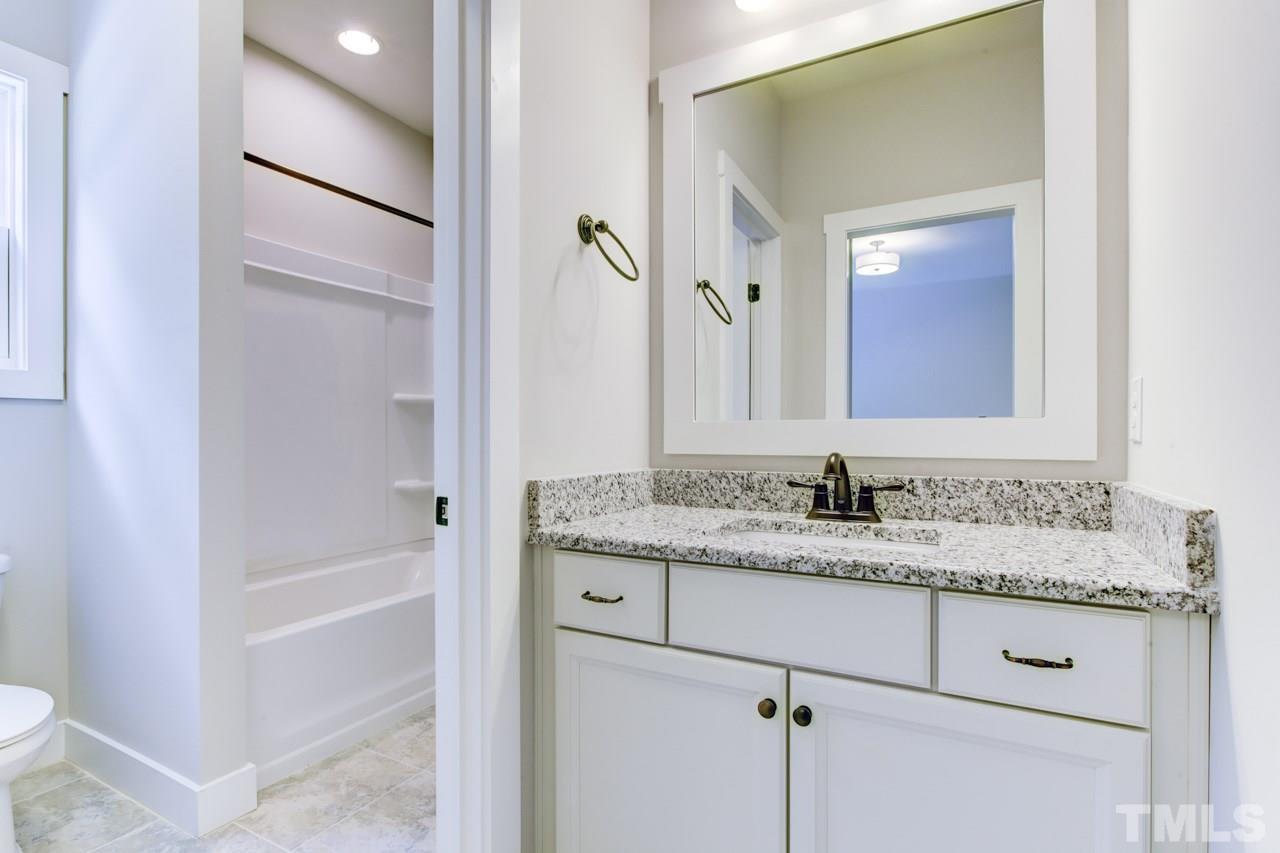 1033 Sky Wave Trail, Unit 8 Raleigh, NC 27603 - Photo 16 of 23 a bathroom with a granite countertop sink and a mirror