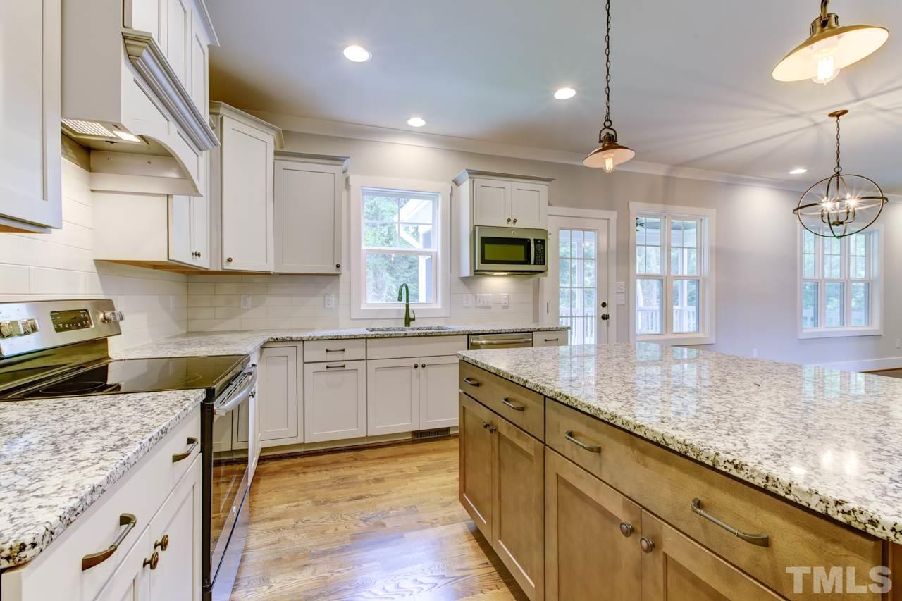 1033 Sky Wave Trail, Unit 8 Raleigh, NC 27603 - Photo 7 of 23 a kitchen with granite countertop a sink a counter space appliances and cabinets