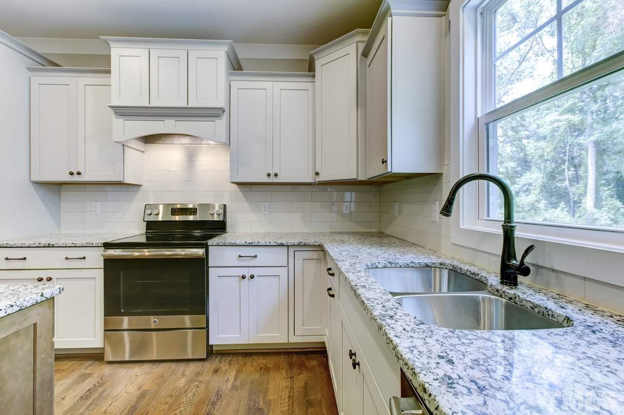 1033 Sky Wave Trail, Unit 8 Raleigh, NC 27603 - Photo 8 of 23 a kitchen with granite countertop a sink stainless steel appliances and cabinets