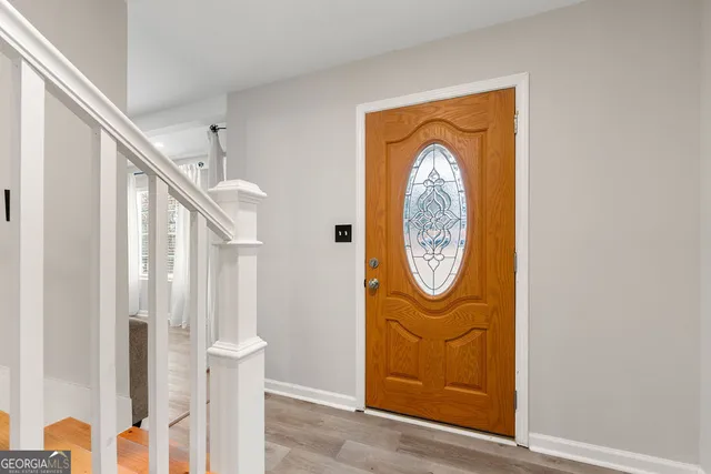 a front view of a house with entryway wooden floor and a table