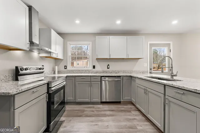 a kitchen with stainless steel appliances granite countertop a sink stove and cabinets