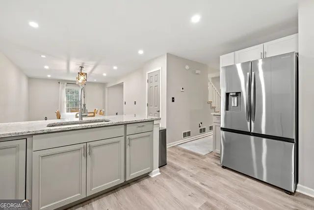 a kitchen with stainless steel appliances a refrigerator sink and cabinets