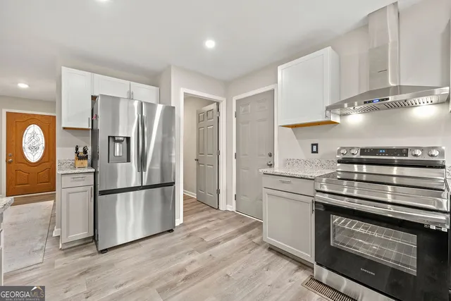 a kitchen with stainless steel appliances granite countertop a refrigerator and a stove top oven