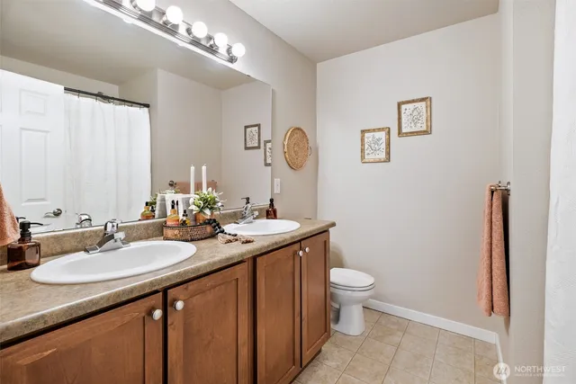 a bathroom with a granite countertop sink a toilet and a mirror