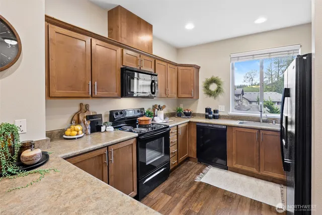 a kitchen with stainless steel appliances granite countertop a stove a sink and a microwave