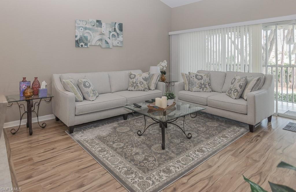 960 Partridge Circle, Unit 1202 Naples, FL 34104 - Photo 1 of 23 a living room with furniture and a wooden floor