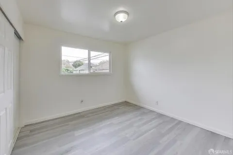 a view of a room with wooden floor and window