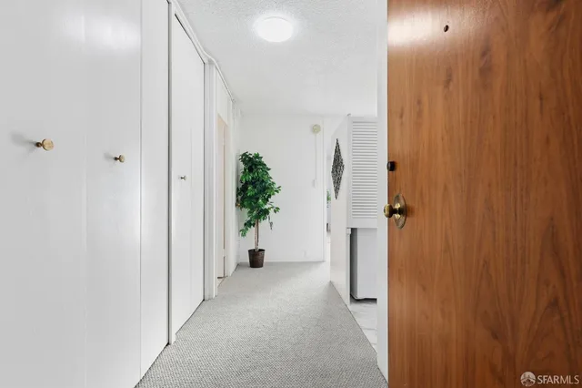 a view of a hallway with wooden shelves