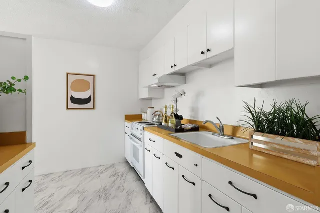 a kitchen with granite countertop a sink a stove and a wooden floors