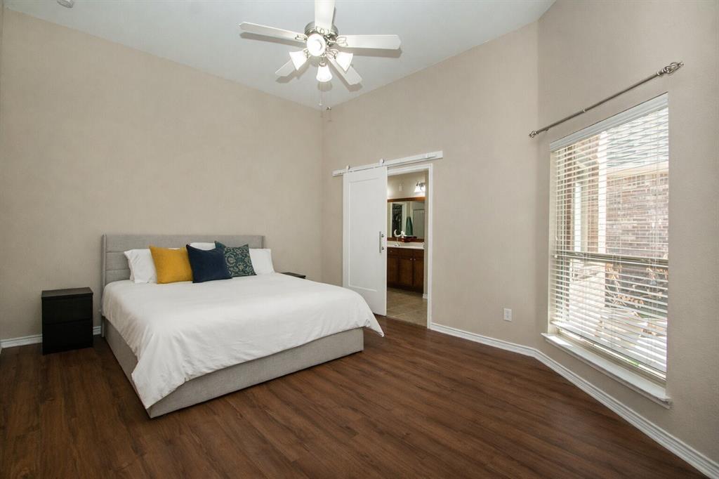 9754 Boyton Canyon Road Frisco, TX 75035 - Photo 3 of 21 a bedroom with a large bed and a chandelier