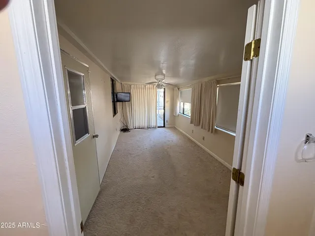 a view of a hallway with wooden floor and staircase