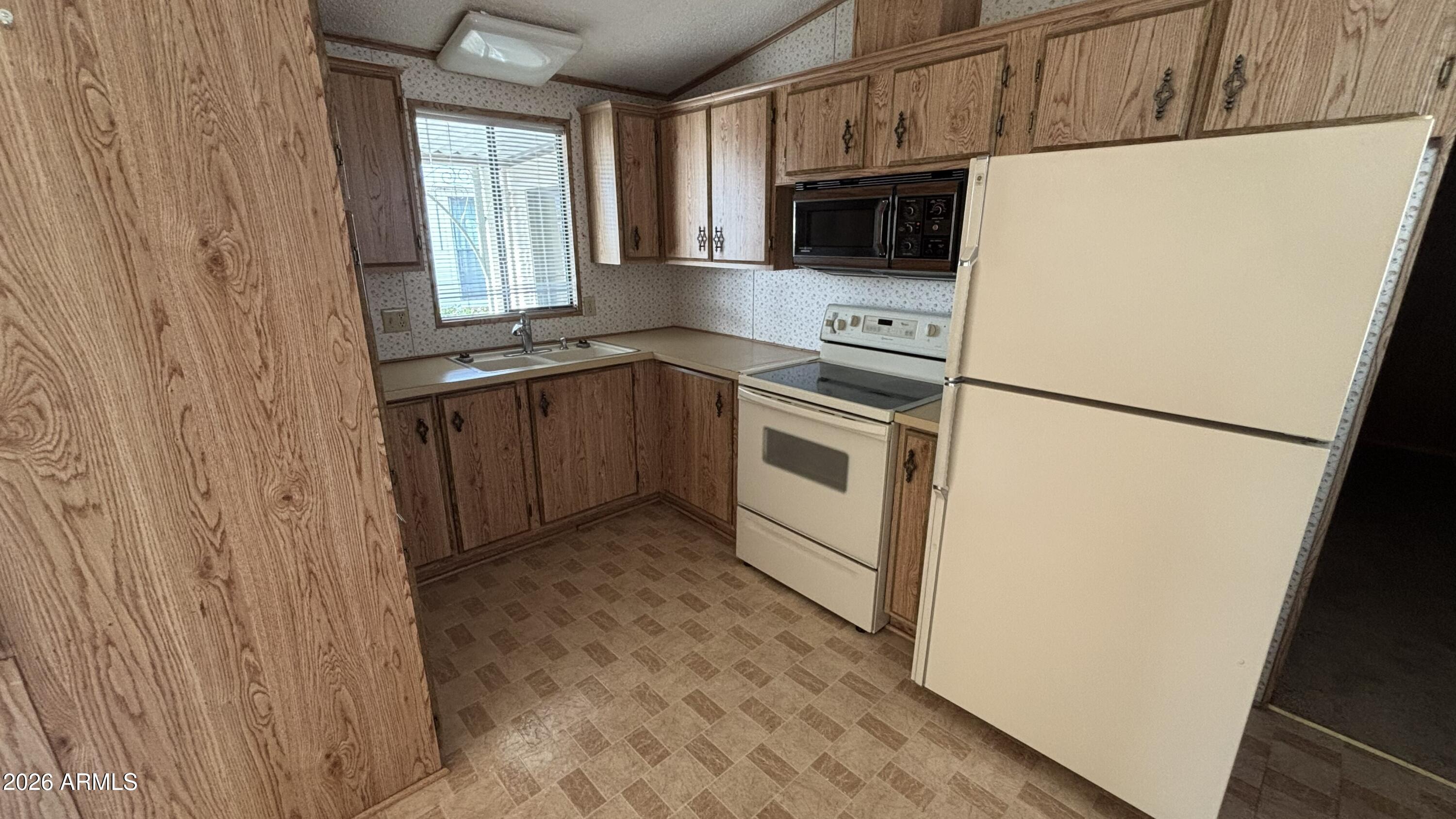 17200 West Bell Road, Unit 2195 Surprise, AZ 85374 - Photo 9 of 27 a kitchen with a refrigerator sink stove and cabinets