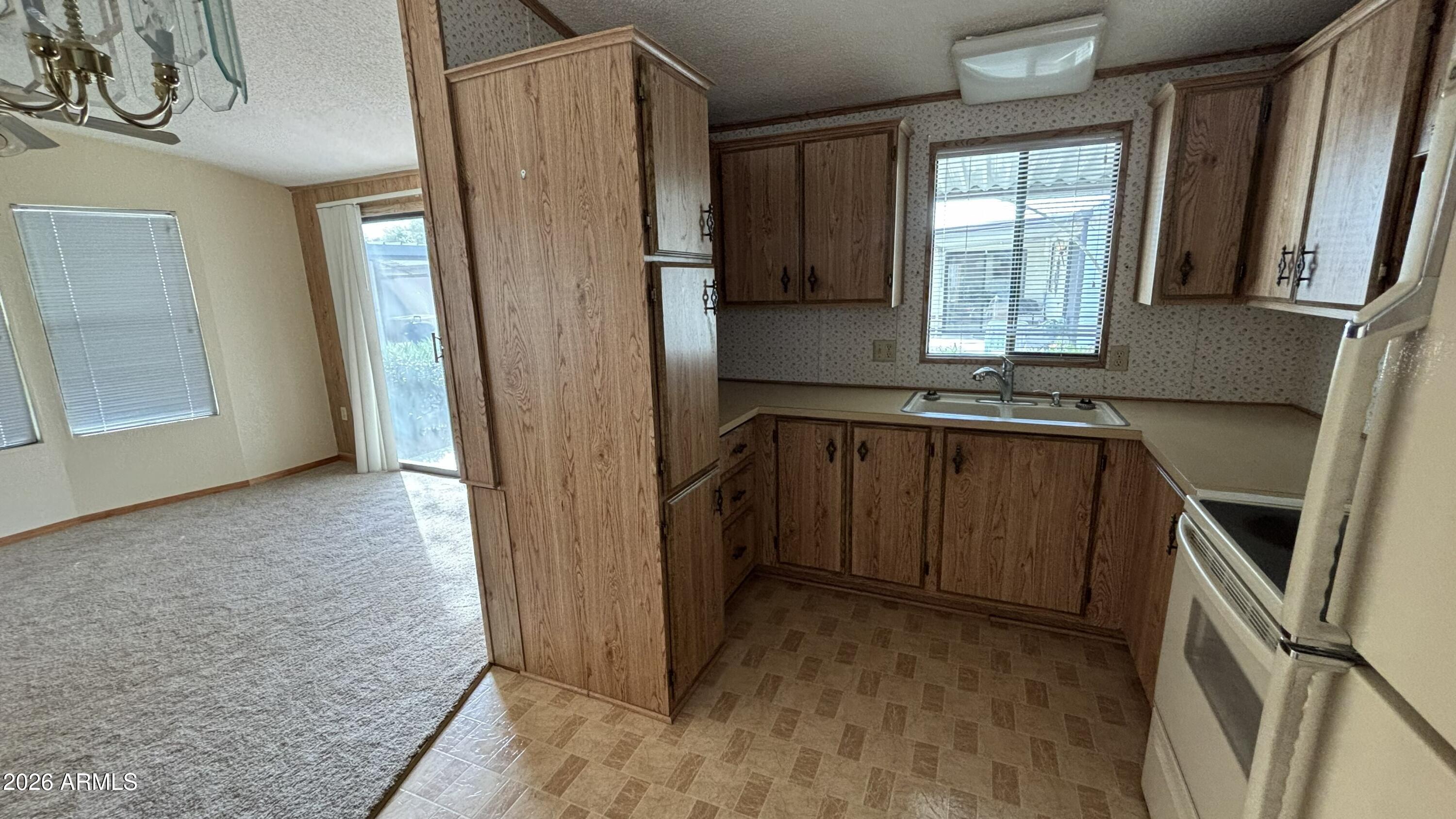 17200 West Bell Road, Unit 2195 Surprise, AZ 85374 - Photo 10 of 27 a view of a kitchen with a sink a refrigerator and window