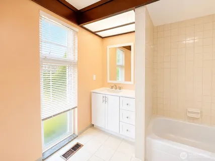 a bathroom with a bathtub sink and mirror