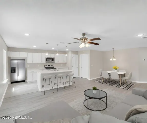 a living room with furniture a rug and kitchen view