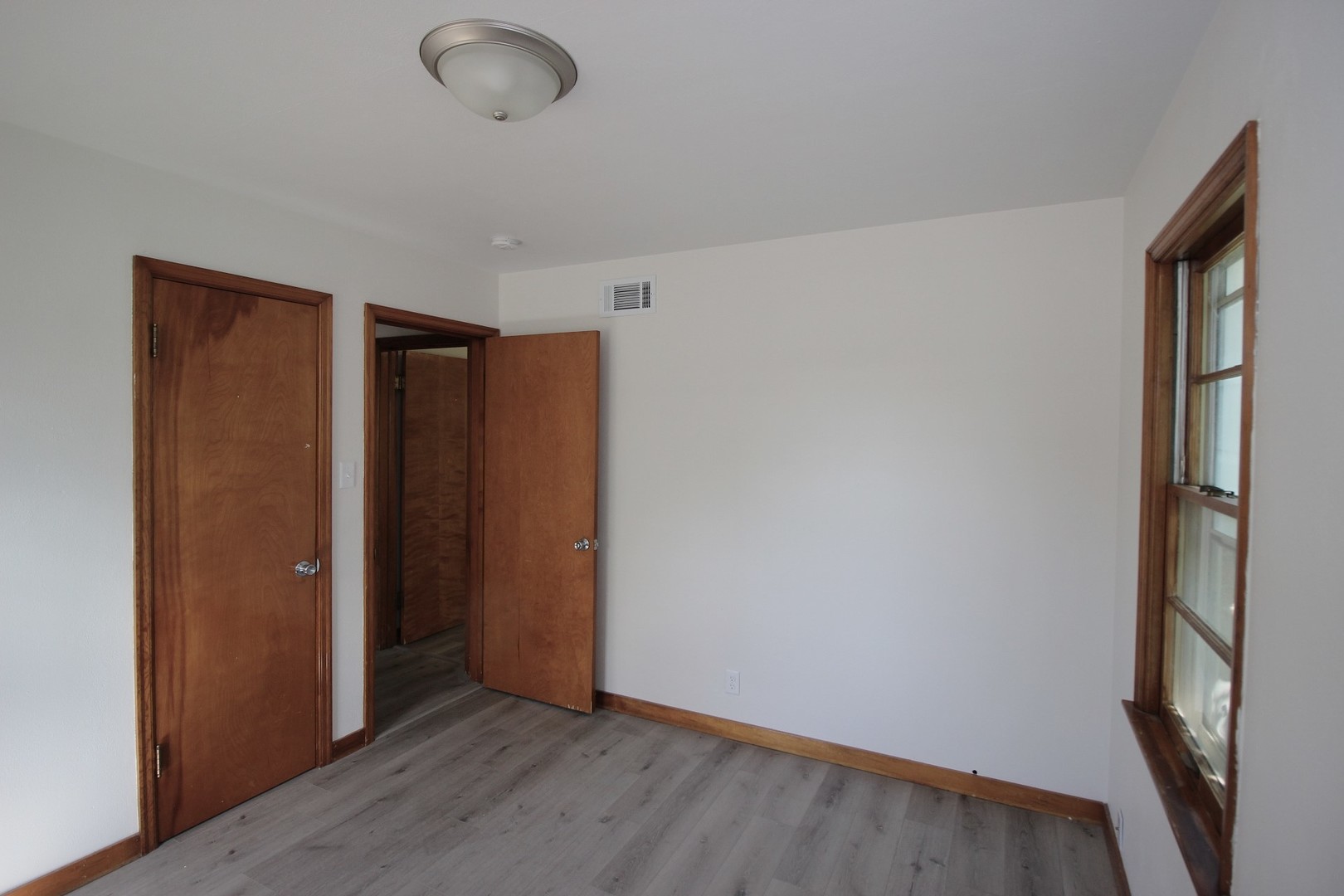 108 East Gridley Road Gridley, IL 61744 - Photo 11 of 22 an empty room with wooden floor and windows