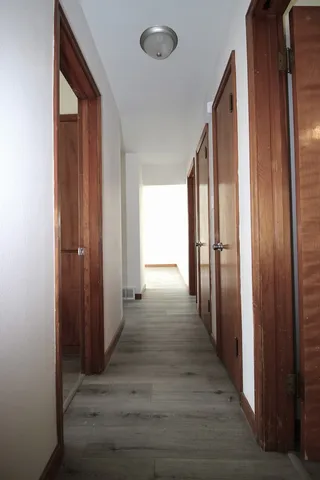 a view of a hallway with wooden floor and staircase