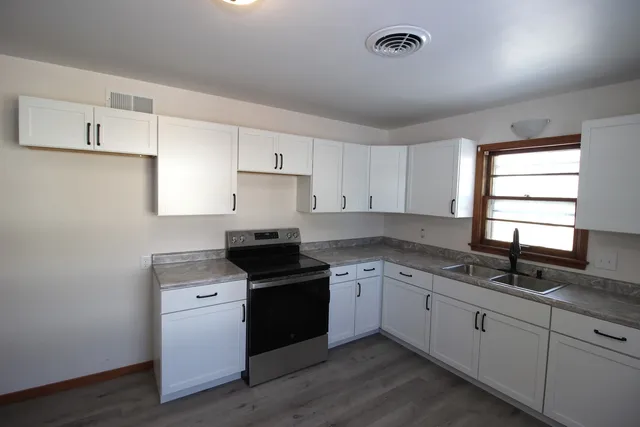 a kitchen with a sink stove and cabinets
