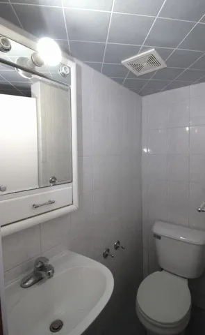 a bathroom with a sink and mirror with toilet