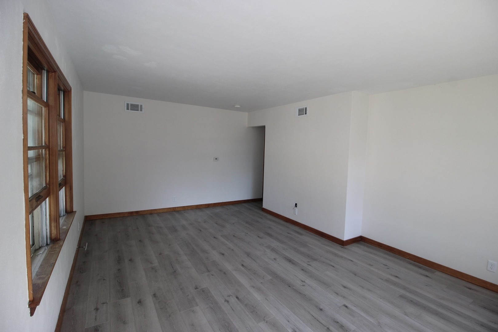 108 East Gridley Road Gridley, IL 61744 - Photo 8 of 22 a view of an empty room with wooden floor and a window