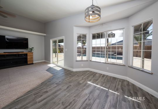 1221 Andrea Court Ridgecrest, CA 93555 - Photo 18 of 50 a view of an empty room with wooden floor and a window