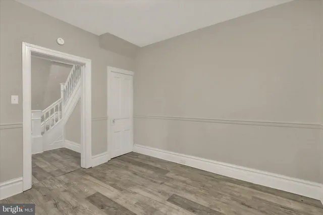 an empty room with wooden floor and white walls