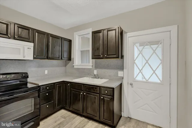 a kitchen with stainless steel appliances granite countertop a sink stove and microwave