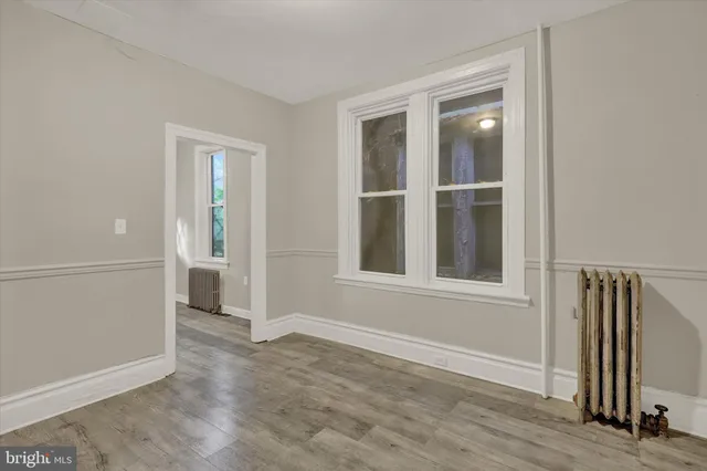 an empty room with wooden floor and a window