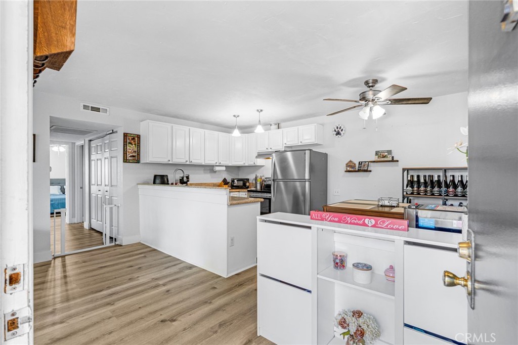 a kitchen with refrigerator cabinets and wooden floor