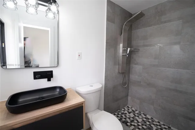 a bathroom with a toilet a sink and shower