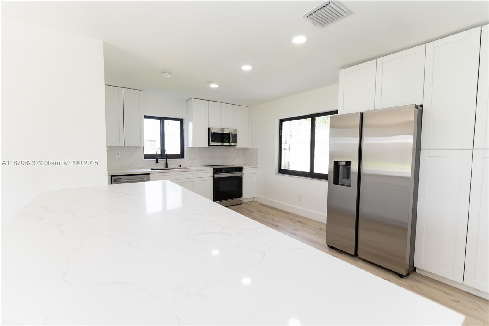 10441 Southwest 50th Terrace Miami, FL 33165 - Photo 7 of 19 a large kitchen with a refrigerator a stove top oven a sink and dishwasher