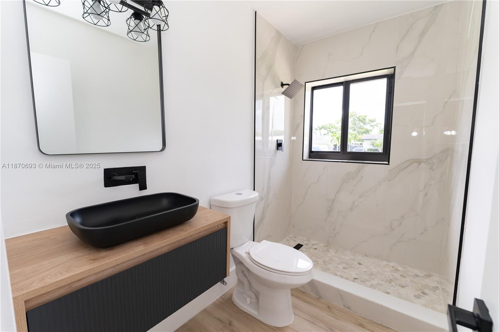 10441 Southwest 50th Terrace Miami, FL 33165 - Photo 8 of 19 a bathroom with a toilet a sink and mirror