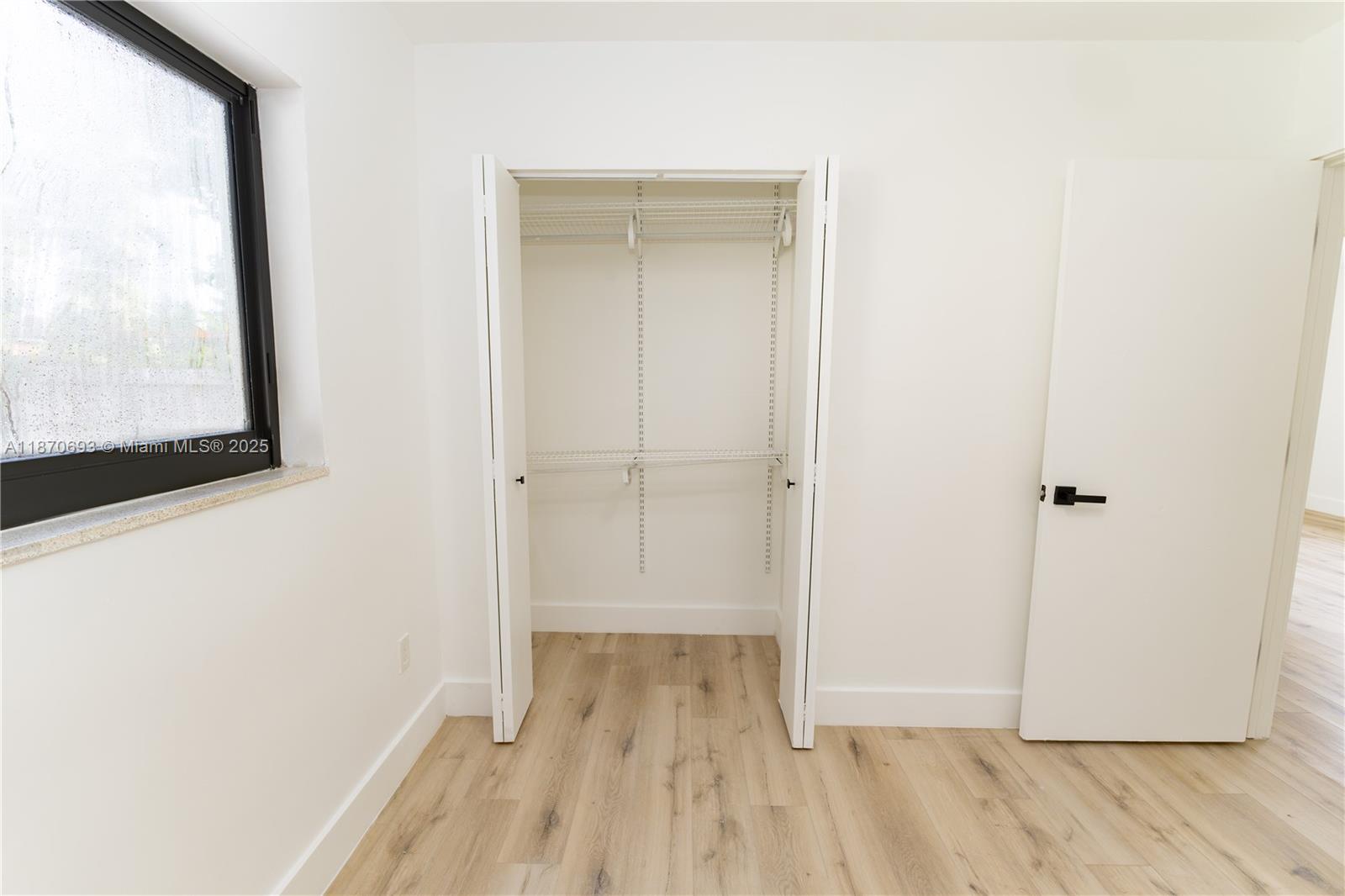 10441 Southwest 50th Terrace Miami, FL 33165 - Photo 9 of 19 a view of a hallway with wooden floor and a bathroom