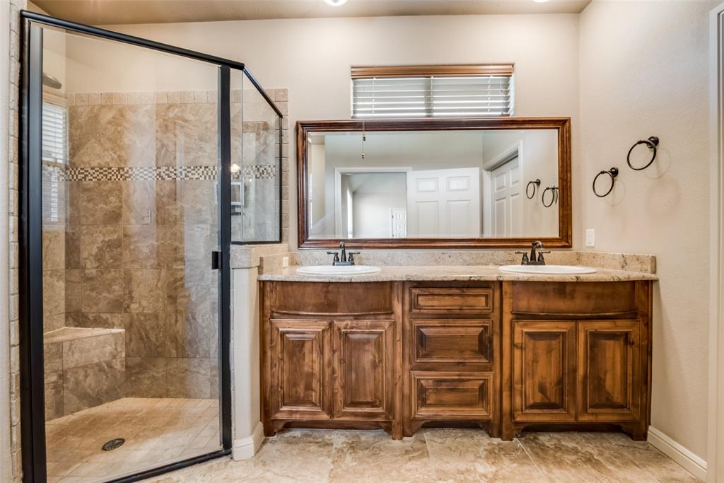 3318 Crystal Clear Court Granbury, TX 76049 - Photo 11 of 18 a bathroom with a granite countertop sink a mirror and a shower