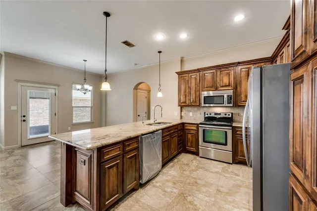 a kitchen with stainless steel appliances granite countertop a sink stove and refrigerator