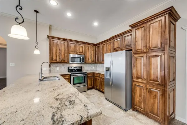 a kitchen with granite countertop stainless steel appliances a refrigerator stove microwave and sink