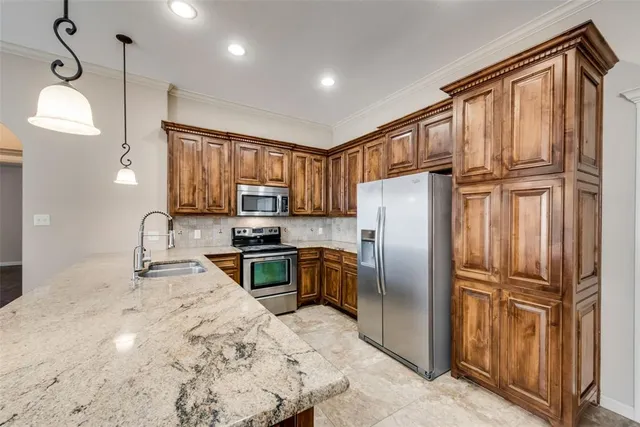 a kitchen with granite countertop stainless steel appliances a refrigerator stove microwave and sink