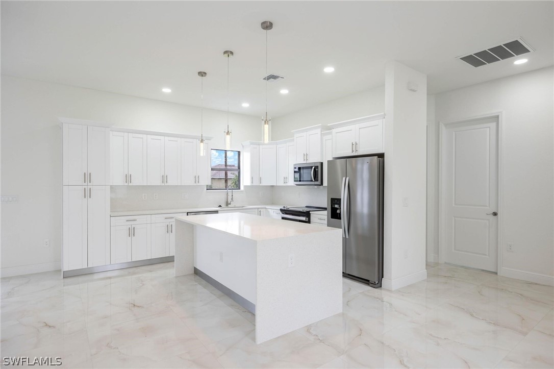 2909 37th Street Southwest Lehigh Acres, FL 33976 - Photo 12 of 29 a large kitchen with a refrigerator a sink dishwasher with a stove and a refrigerator