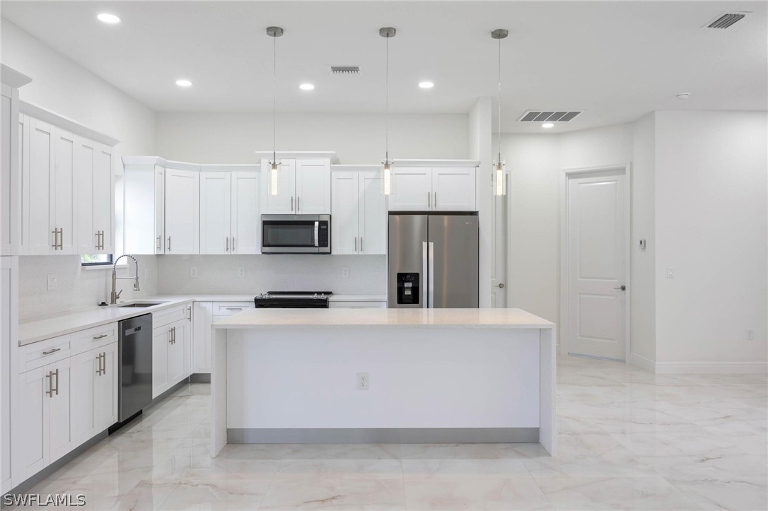 2909 37th Street Southwest Lehigh Acres, FL 33976 - Photo 15 of 29 a large kitchen with stainless steel appliances granite countertop a stove a sink and a refrigerator