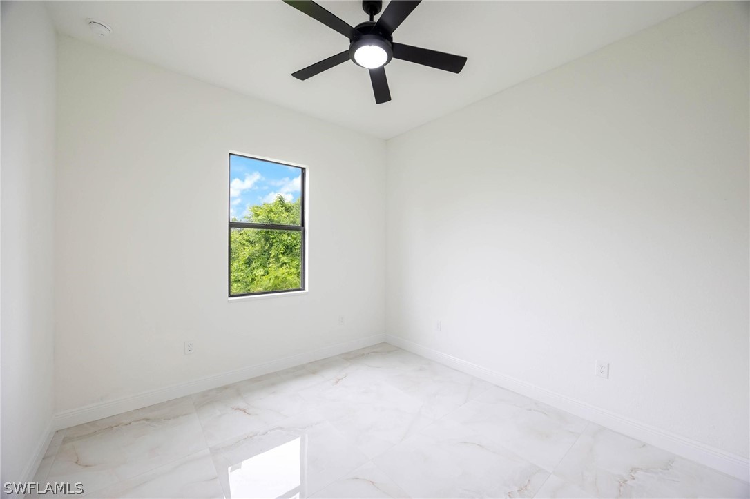 2909 37th Street Southwest Lehigh Acres, FL 33976 - Photo 19 of 29 an empty room with a window and a fan