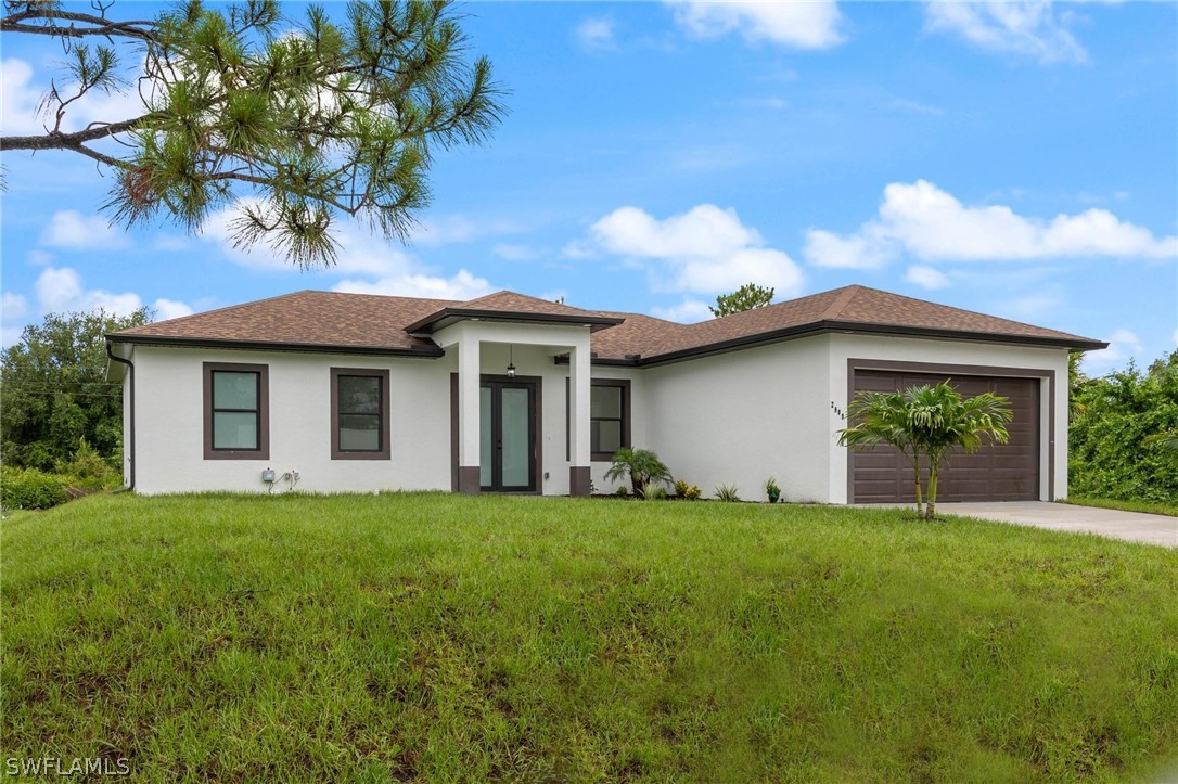 2909 37th Street Southwest Lehigh Acres, FL 33976 - Photo 2 of 29 a view of a house with a yard and a garden