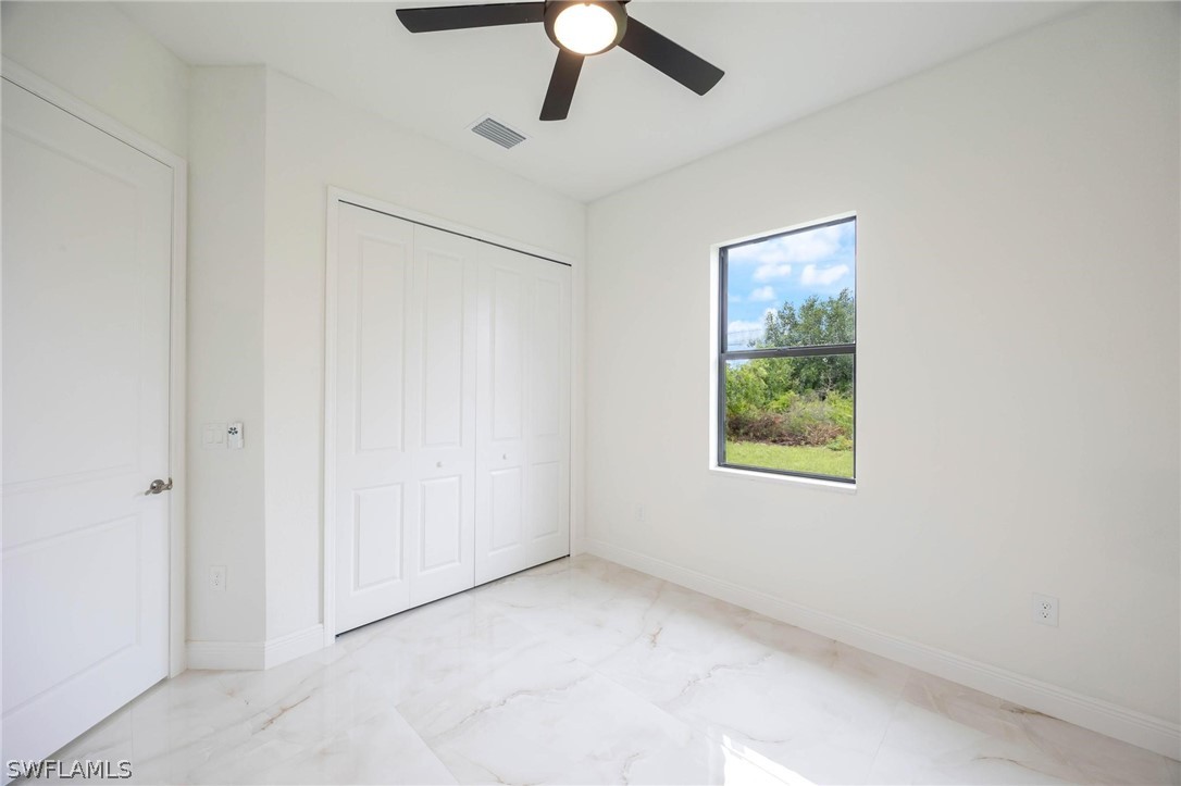 2909 37th Street Southwest Lehigh Acres, FL 33976 - Photo 21 of 29 an empty room with a window and a ceiling fan